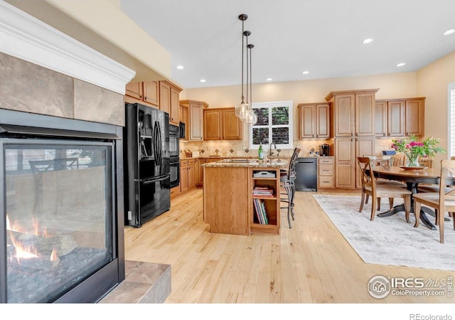 15002 Cosmos Way, Broomfield, CO 80023 - kitchen with black appliances, a kitchen island, backsplash, light wood-style floors, and decorative light fixtures