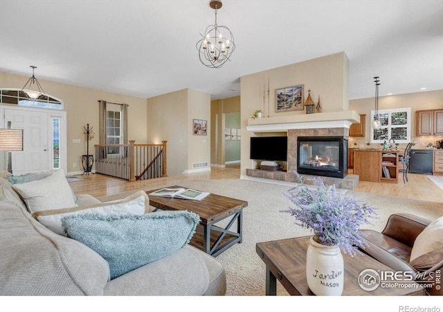 15002 Cosmos Way, Broomfield, CO 80023 - living room featuring a fireplace, a chandelier, recessed lighting, and light wood-style floors