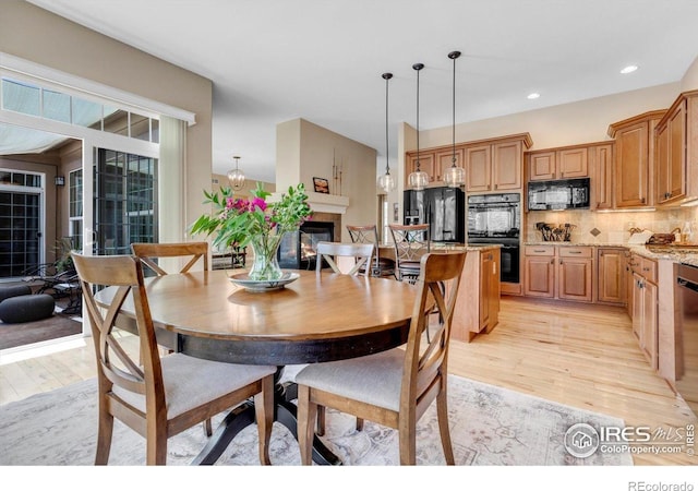 15002 Cosmos Way, Broomfield, CO 80023 - dining space with light wood-style floors, recessed lighting, and a glass covered fireplace