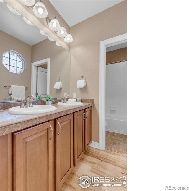 15002 Cosmos Way, Broomfield, CO 80023 - full bathroom featuring double vanity, shower / tub combination, and wood finished floors
