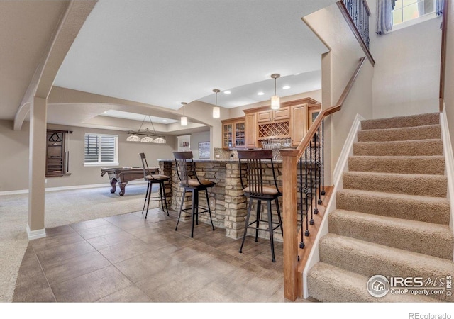 15002 Cosmos Way, Broomfield, CO 80023 - kitchen with recessed lighting, a breakfast bar, glass insert cabinets, pool table, and decorative light fixtures