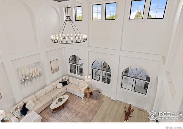 16636 Krameria Way, Brighton, CO 80602 - living area with a chandelier, wood finished floors, and a towering ceiling