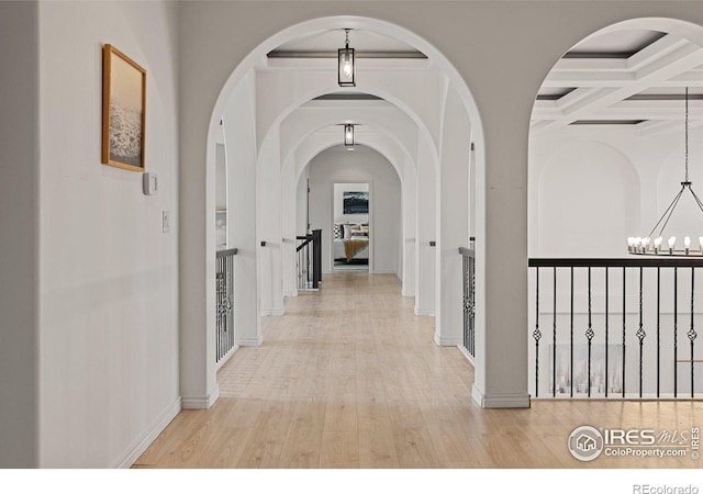 16636 Krameria Way, Brighton, CO 80602 - hallway with a chandelier, wood finished floors, arched walkways, and beamed ceiling