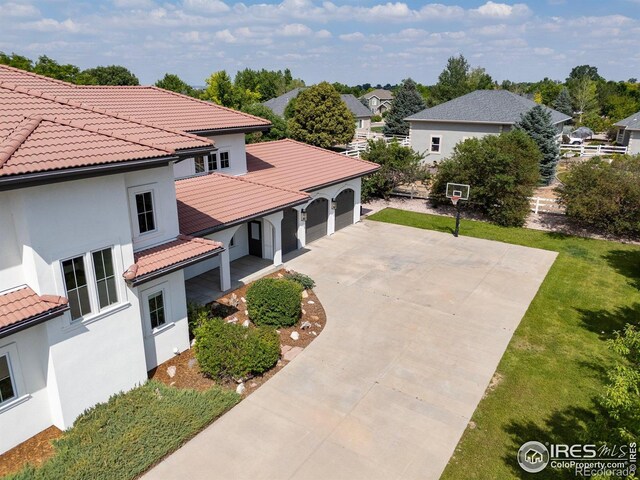 16636 Krameria Way, Brighton, CO 80602 - exterior space featuring a tiled roof, driveway, a garage, stucco siding, and a yard