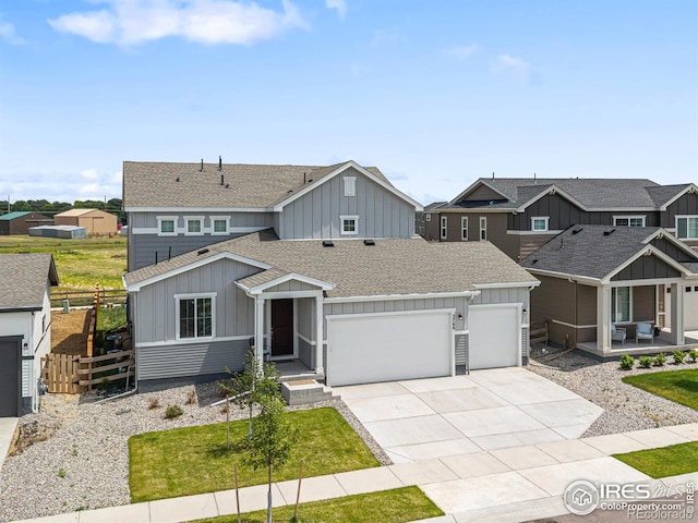 5766 Ranch St, Longmont, CO 80504 - view of front of home featuring an attached garage, board and batten siding, a shingled roof, and driveway