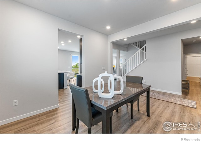 5766 Ranch St, Longmont, CO 80504 - dining space featuring light wood-type flooring, stairway, and recessed lighting