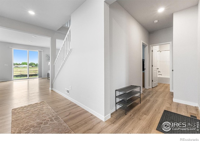 5766 Ranch St, Longmont, CO 80504 - hall featuring light wood-type flooring, stairs, and recessed lighting