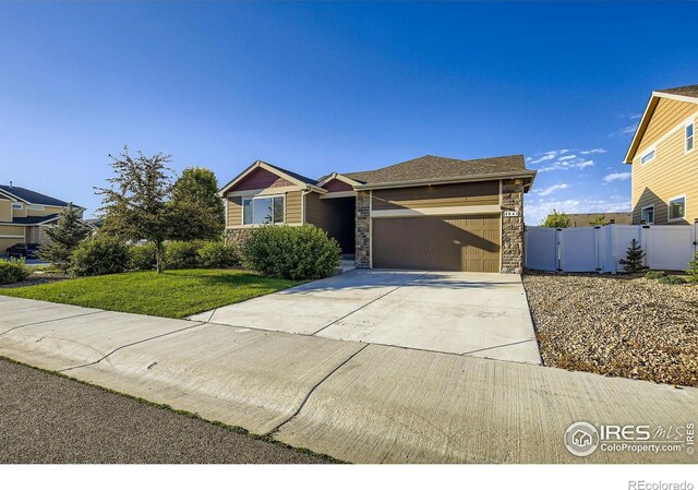 1541 Water Vista Ln, Severance, CO 80550 - view of front of home with an attached garage, stone siding, and concrete driveway