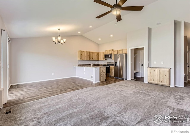 1541 Water Vista Ln, Severance, CO 80550 - unfurnished living room featuring a ceiling fan, a chandelier, dark wood-type flooring, high vaulted ceiling, and dark colored carpet