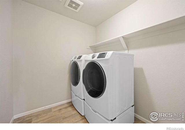 5217 Alberta Falls St, Timnath, CO 80547 - laundry area with washing machine and dryer and light wood-style flooring