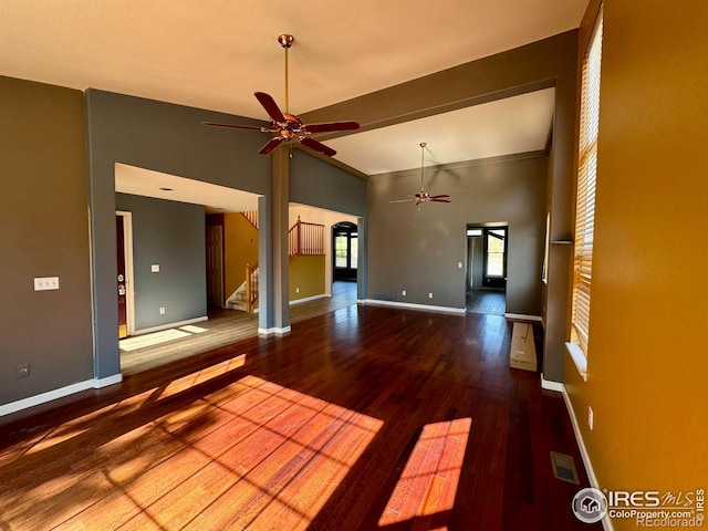 2395 Sandpiper Dr, Lafayette, CO 80026 - unfurnished living room featuring a ceiling fan, wood finished floors, stairway, lofted ceiling, and arched walkways