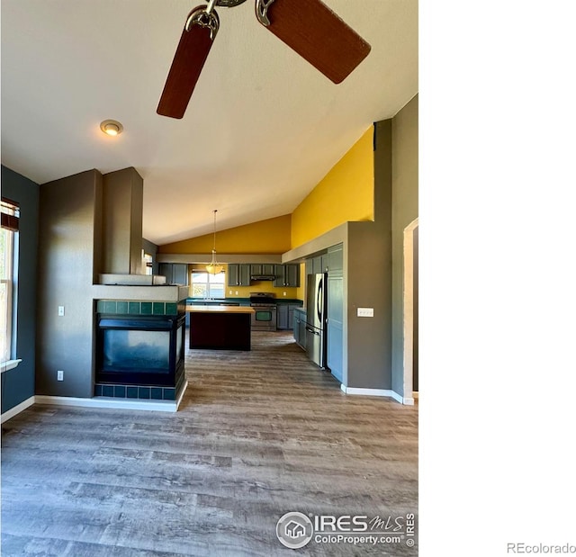2395 Sandpiper Dr, Lafayette, CO 80026 - kitchen featuring appliances with stainless steel finishes, vaulted ceiling, wood finished floors, under cabinet range hood, and pendant lighting