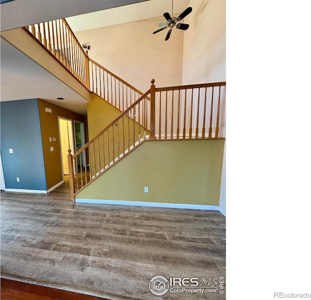 2395 Sandpiper Dr, Lafayette, CO 80026 - stairway featuring a ceiling fan, wood finished floors, and a high ceiling