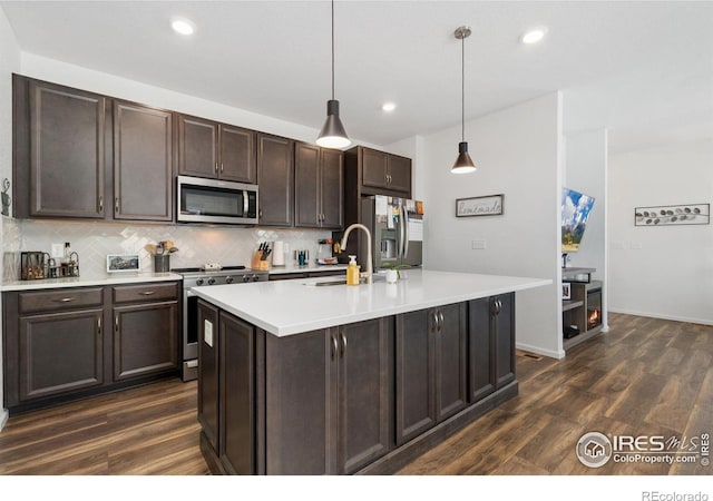 14203 Hop Clover Trl, Parker, CO 80134 - kitchen featuring appliances with stainless steel finishes, decorative backsplash, dark brown cabinets, dark wood-style floors, and recessed lighting