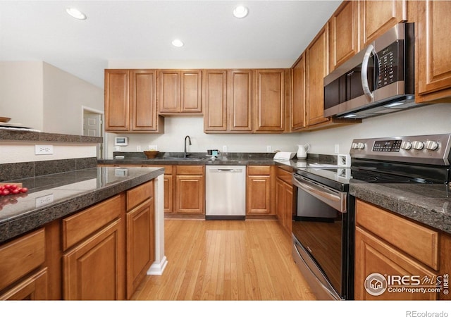 3882 W 118th Pl, Westminster, CO 80031 - kitchen featuring stainless steel appliances, light wood finished floors, recessed lighting, brown cabinets, and tile countertops