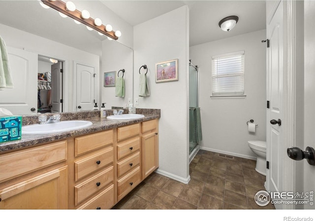 2302 74th Ave, Greeley, CO 80634 - bathroom featuring double vanity, a shower stall, and a closet
