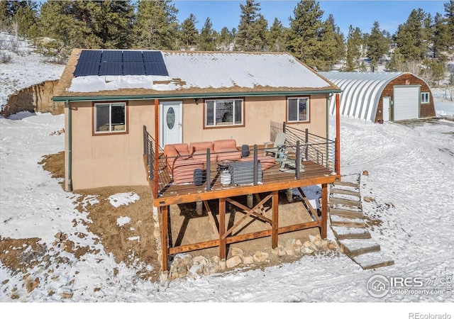 3367 Badger Creek Rd, Hartsel, CO 80449 - snow covered property with roof mounted solar panels, a garage, an outdoor structure, and a wooden deck