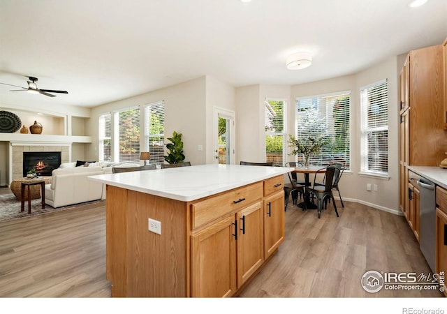 2262 Harvest St, Fort Collins, CO 80528 - kitchen with light wood-style floors, a tiled fireplace, dishwasher, and a center island