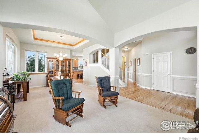 1145 Wyndemere Cir, Longmont, CO 80504 - carpeted living area with arched walkways, a chandelier, and stairs