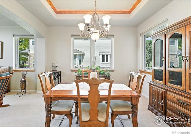 1145 Wyndemere Cir, Longmont, CO 80504 - dining room with a chandelier, healthy amount of natural light, light colored carpet, and a tray ceiling