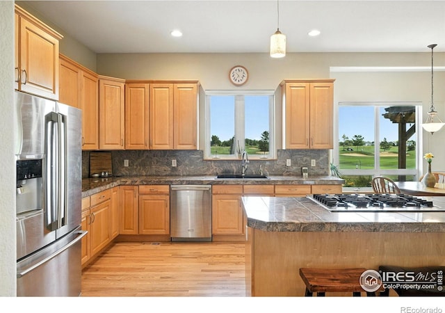 1145 Wyndemere Cir, Longmont, CO 80504 - kitchen featuring stainless steel appliances, tile countertops, light wood-style flooring, hanging light fixtures, and recessed lighting