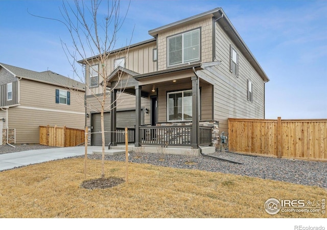 9929 Ceylon Ct, Commerce City, CO 80022 - view of front of property with covered porch, driveway, a garage, and board and batten siding