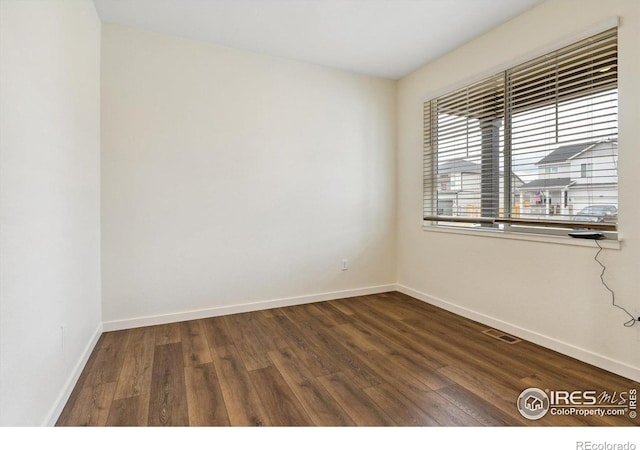 9929 Ceylon Ct, Commerce City, CO 80022 - unfurnished room featuring baseboards and dark wood-style flooring