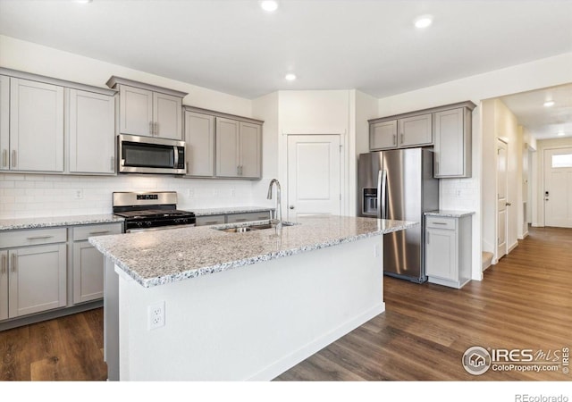 9929 Ceylon Ct, Commerce City, CO 80022 - kitchen featuring appliances with stainless steel finishes, gray cabinets, dark wood-style flooring, recessed lighting, and decorative backsplash