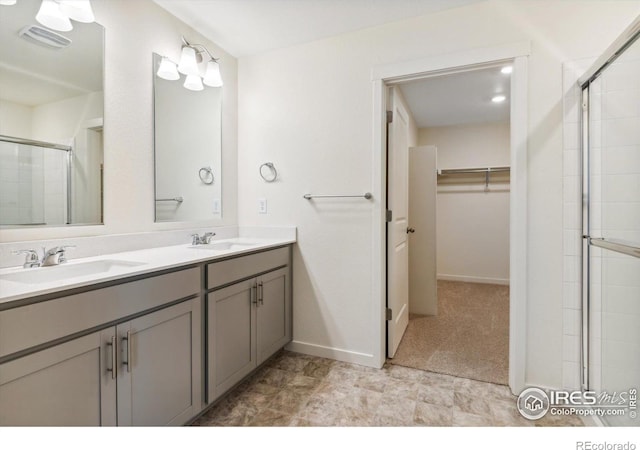 9929 Ceylon Ct, Commerce City, CO 80022 - bathroom with a walk in closet, tiled shower, and double vanity