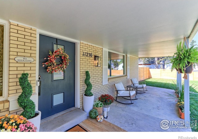 11230 W 77th Dr, Arvada, CO 80005 - property entrance featuring brick siding and covered porch