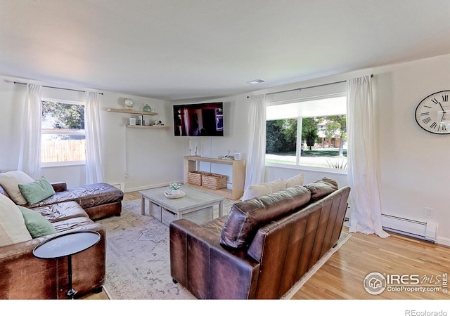 11230 W 77th Dr, Arvada, CO 80005 - living room featuring baseboard heating, healthy amount of natural light, and light wood-type flooring