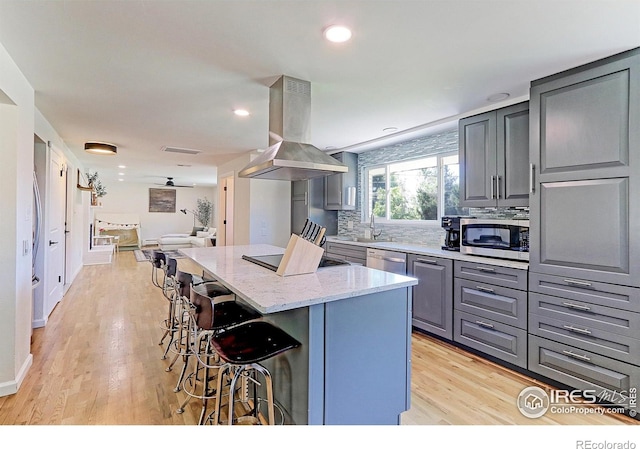 11230 W 77th Dr, Arvada, CO 80005 - kitchen featuring island range hood, appliances with stainless steel finishes, gray cabinetry, a breakfast bar area, and a kitchen island