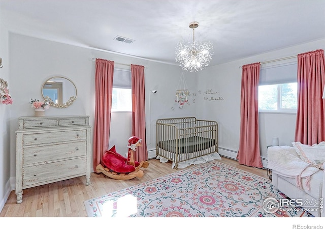 11230 W 77th Dr, Arvada, CO 80005 - bedroom with multiple windows, a chandelier, wood finished floors, and a baseboard radiator