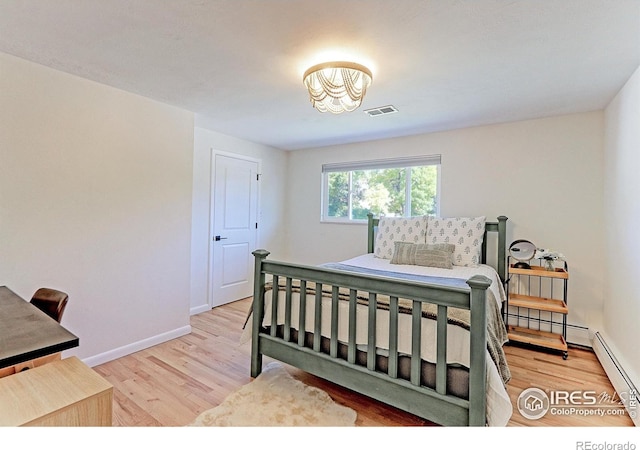 11230 W 77th Dr, Arvada, CO 80005 - bedroom featuring light wood-type flooring, a chandelier, and baseboard heating