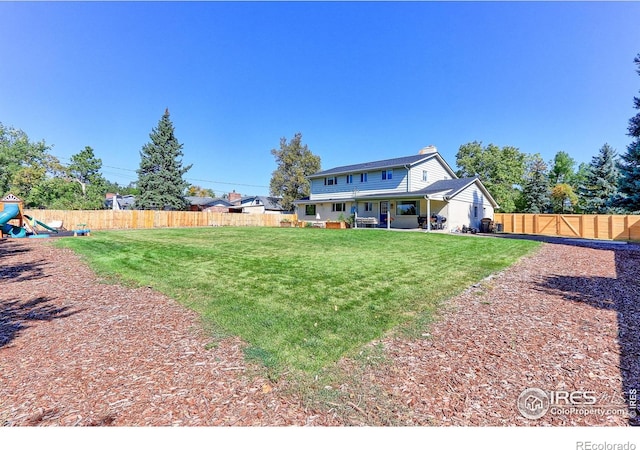 11230 W 77th Dr, Arvada, CO 80005 - rear view of house with a fenced backyard, a playground, and a patio area