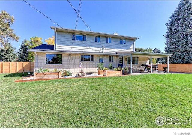 11230 W 77th Dr, Arvada, CO 80005 - rear view of property featuring a patio area, a fenced backyard, brick siding, and a vegetable garden
