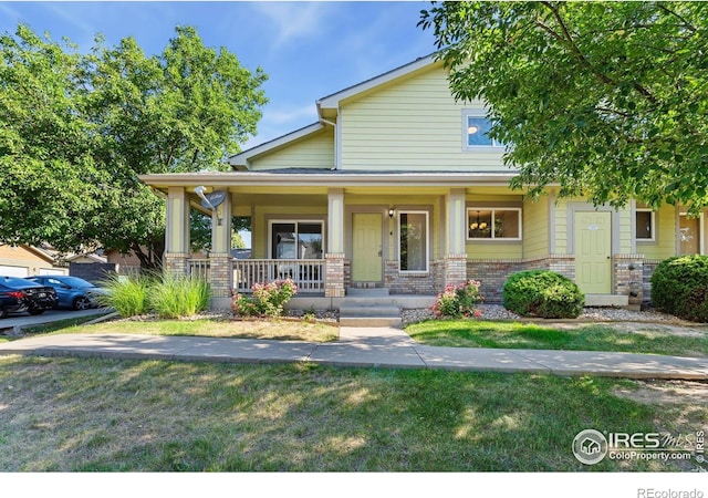 2702 Rigden Pkwy Unit F4, Fort Collins, CO 80525 - view of front of property with brick siding, a porch, and a front lawn