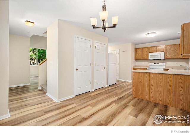 2702 Rigden Pkwy Unit F4, Fort Collins, CO 80525 - kitchen with white appliances, light wood finished floors, light countertops, a chandelier, and decorative light fixtures