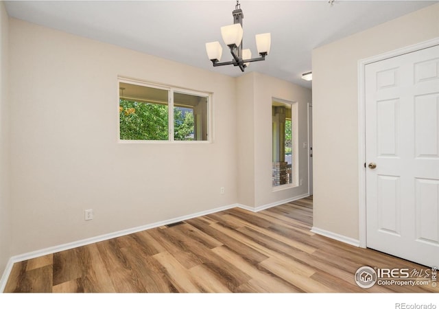 2702 Rigden Pkwy Unit F4, Fort Collins, CO 80525 - empty room featuring a chandelier and wood finished floors