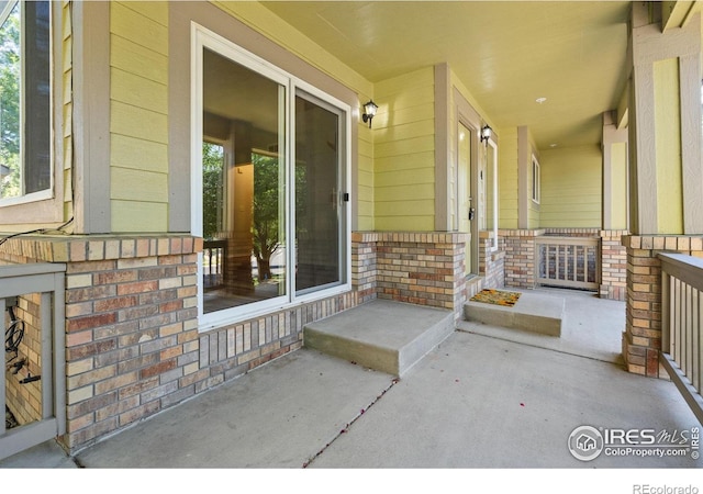 2702 Rigden Pkwy Unit F4, Fort Collins, CO 80525 - view of exterior entry with brick siding and a porch