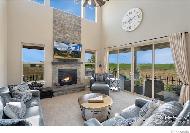 3304 Heron Lakes Pkwy, Berthoud, CO 80513 - carpeted living room featuring a high ceiling, ceiling fan, and a fireplace