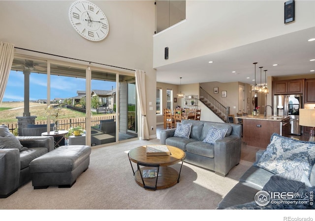 3304 Heron Lakes Pkwy, Berthoud, CO 80513 - living area featuring a wood stove, a chandelier, light colored carpet, stairs, and recessed lighting