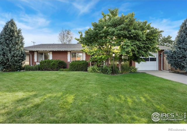 821 36th Ave, Greeley, CO 80634 - view of front of property with brick siding, a front lawn, a garage, and concrete driveway