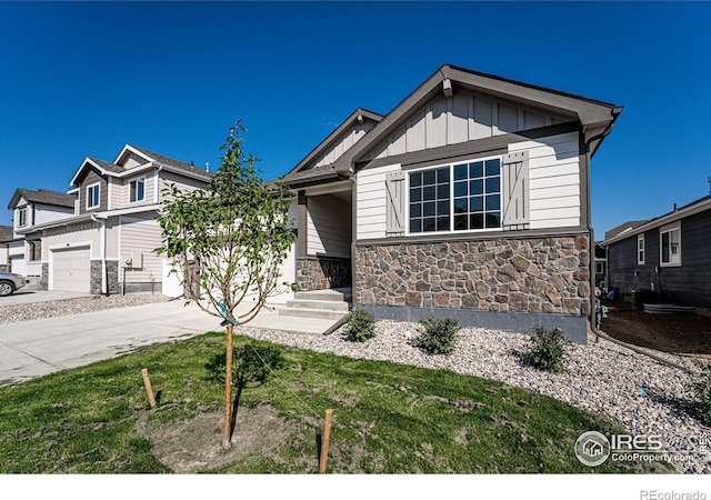 604 Rosedale St, Severance, CO 80550 - view of front of property with stone siding, concrete driveway, board and batten siding, and a front lawn