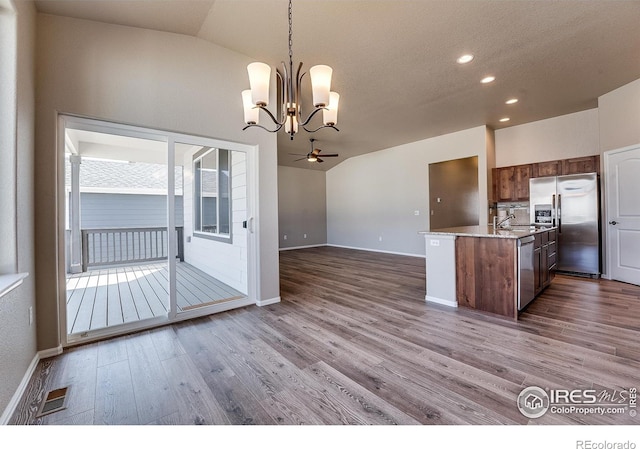 604 Rosedale St, Severance, CO 80550 - kitchen with stainless steel appliances, vaulted ceiling, open floor plan, dark wood-style flooring, and recessed lighting