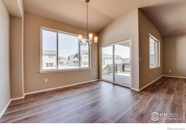 604 Rosedale St, Severance, CO 80550 - unfurnished dining area with healthy amount of natural light, vaulted ceiling, a chandelier, and wood finished floors