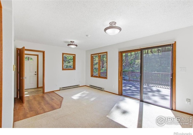 2160 Devils Gulch Rd, Estes Park, CO 80517 - carpeted spare room with a baseboard heating unit, healthy amount of natural light, and a textured ceiling