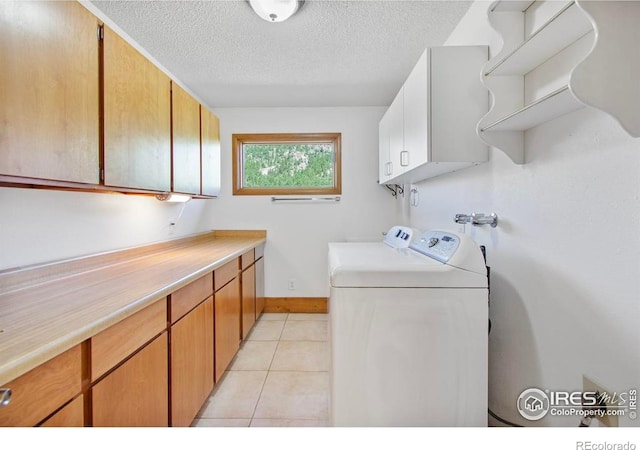2160 Devils Gulch Rd, Estes Park, CO 80517 - laundry room with cabinet space, a textured ceiling, washing machine and dryer, and light tile patterned floors