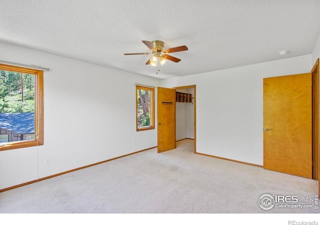 2160 Devils Gulch Rd, Estes Park, CO 80517 - unfurnished bedroom with carpet flooring, a textured ceiling, a ceiling fan, and a closet