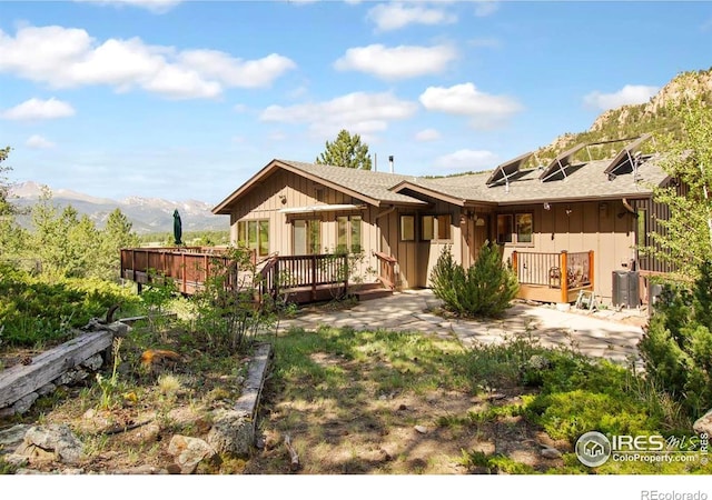 2160 Devils Gulch Rd, Estes Park, CO 80517 - rear view of property with a deck with mountain view, board and batten siding, and roof with shingles